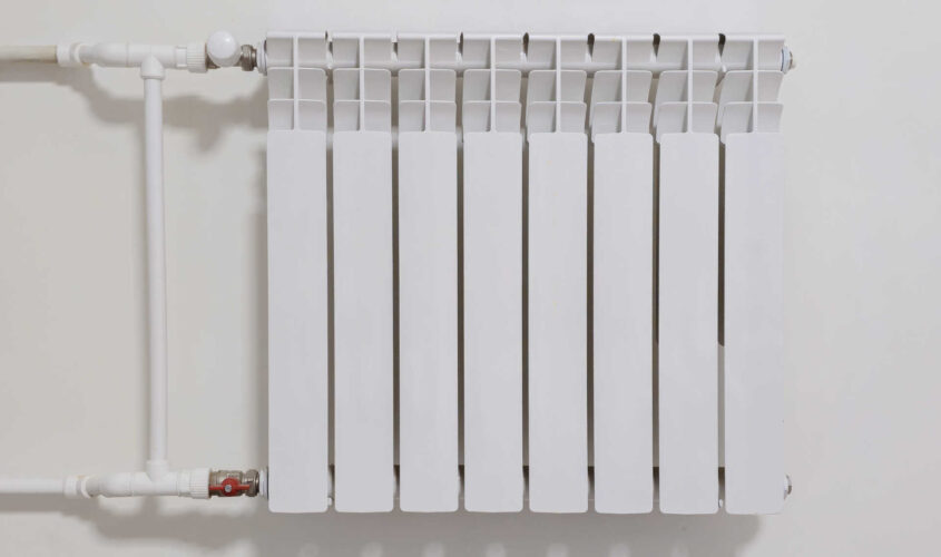 A white radiator with a white pipe attached to it