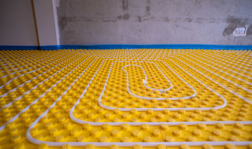 yellow underfloor heating installation with white pipes