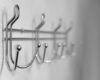 Extremely close-up metal coat hooks on white wall, selective focus